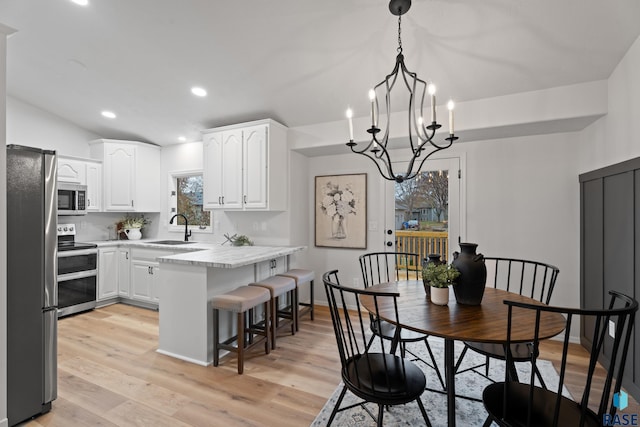 kitchen featuring white cabinetry, sink, light wood-type flooring, and appliances with stainless steel finishes