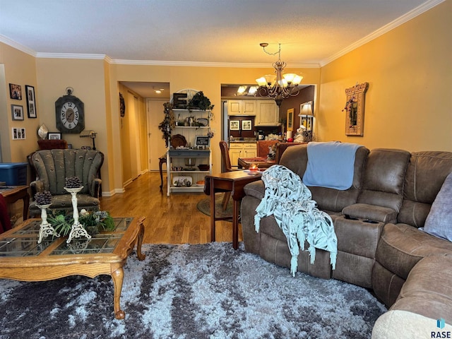 living room featuring crown molding, hardwood / wood-style floors, and a notable chandelier