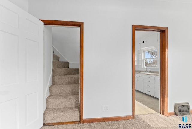 stairs with carpet and sink