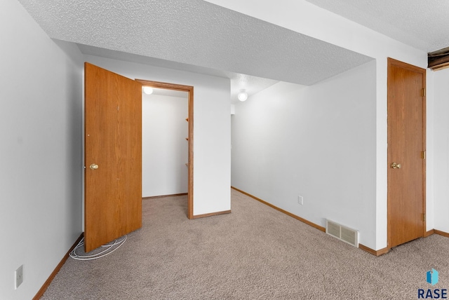 basement featuring carpet and a textured ceiling