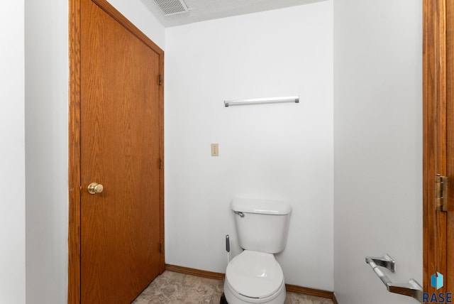 bathroom with a textured ceiling and toilet