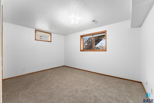 unfurnished room featuring carpet and a textured ceiling