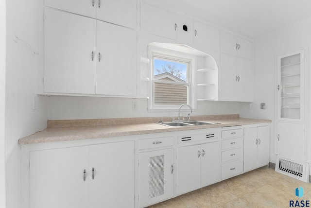 kitchen featuring white cabinets, light tile patterned floors, and sink