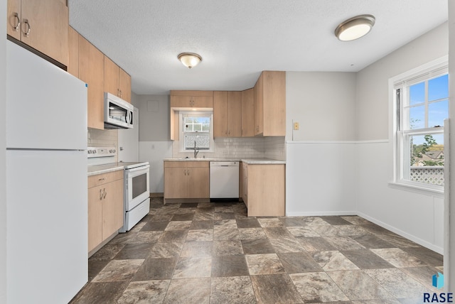 kitchen featuring a textured ceiling, white appliances, sink, and tasteful backsplash