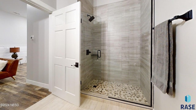 bathroom with hardwood / wood-style floors and a shower with door