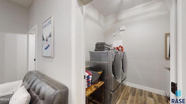 laundry room with hardwood / wood-style floors and washing machine and clothes dryer