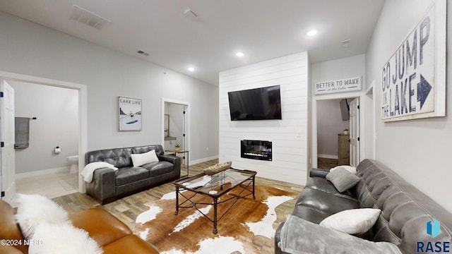 living room with a large fireplace and light hardwood / wood-style floors