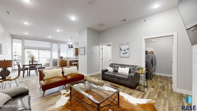 living room featuring washer and dryer and light hardwood / wood-style flooring