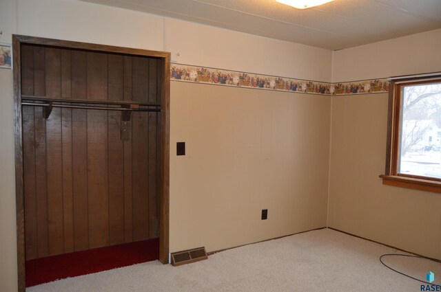 unfurnished bedroom featuring carpet flooring and a closet