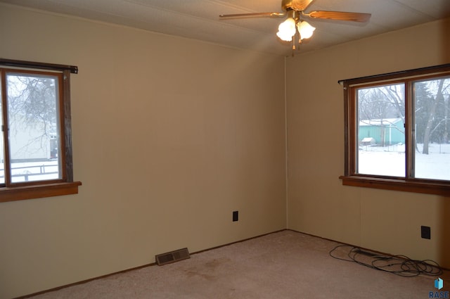 empty room with ceiling fan and light colored carpet