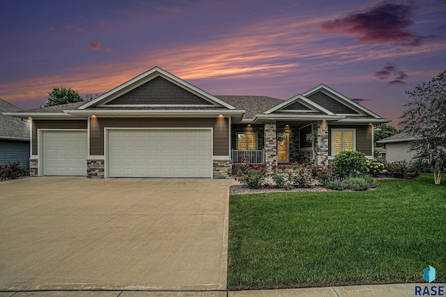 craftsman house with a lawn, a garage, and covered porch