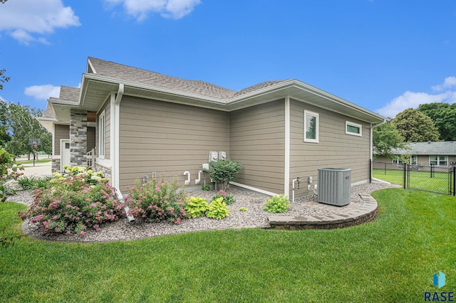 view of side of home featuring a yard and central air condition unit