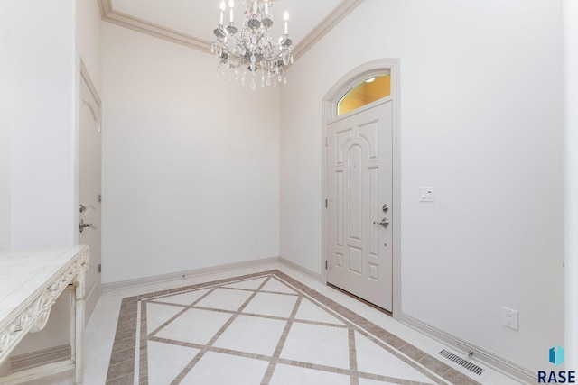 foyer with ornamental molding and a chandelier