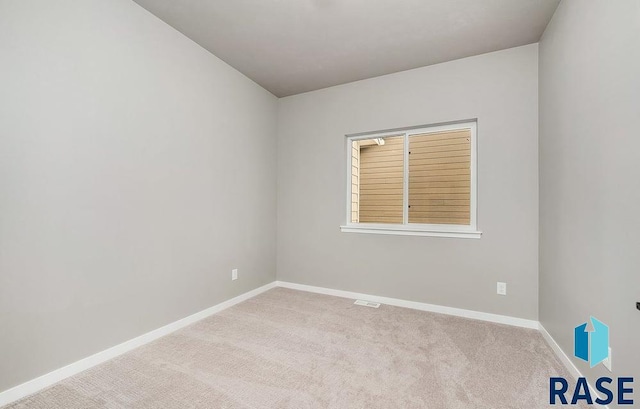 spare room featuring light colored carpet