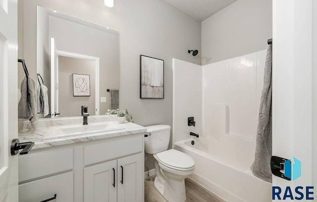 full bathroom featuring toilet, wood-type flooring, vanity, and bathing tub / shower combination