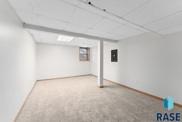 basement featuring electric panel, a paneled ceiling, and carpet