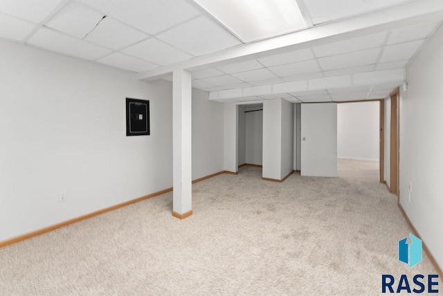 basement with electric panel, light colored carpet, and a drop ceiling