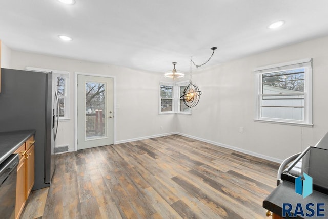 unfurnished dining area with a healthy amount of sunlight and dark hardwood / wood-style flooring