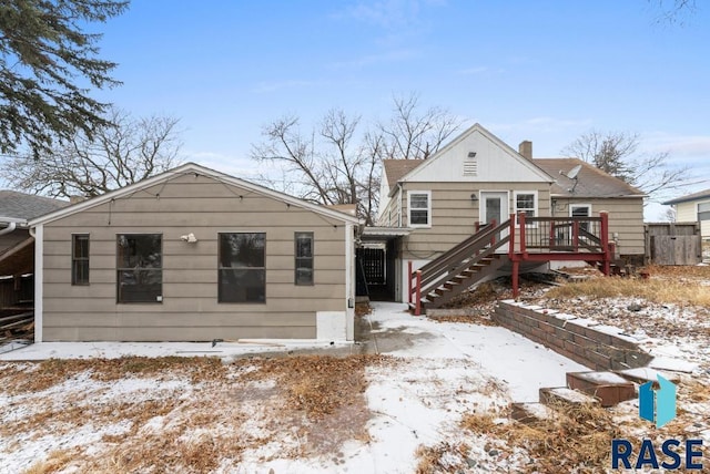 snow covered house featuring a wooden deck