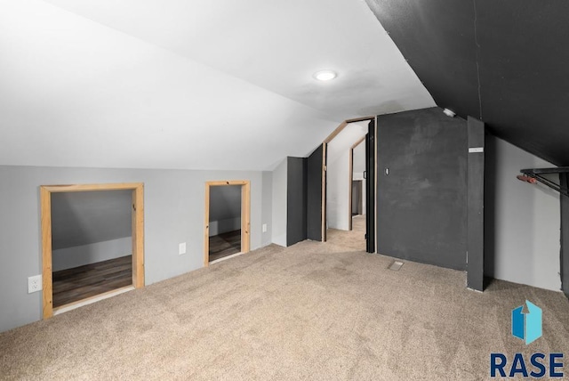 bonus room featuring light carpet and vaulted ceiling