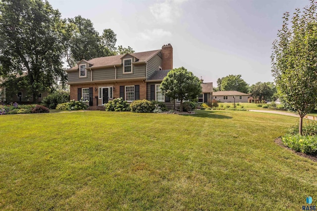 view of front facade featuring a front yard, brick siding, and a chimney