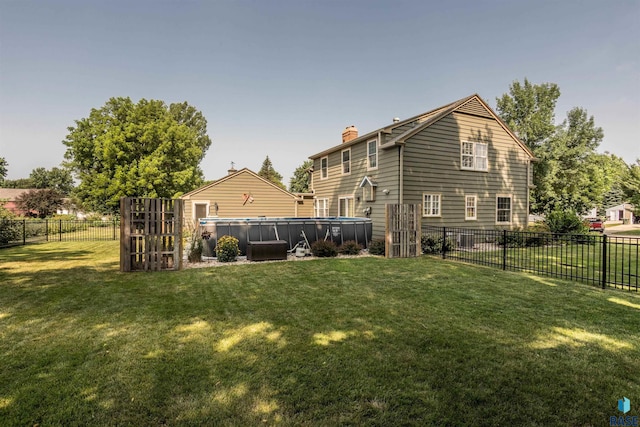 rear view of property featuring a yard and a fenced in pool