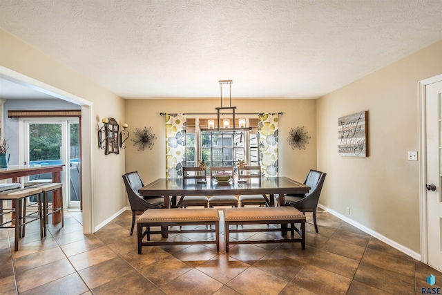 dining room featuring a textured ceiling and an inviting chandelier