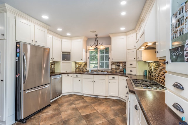 kitchen featuring appliances with stainless steel finishes, tasteful backsplash, hanging light fixtures, and sink