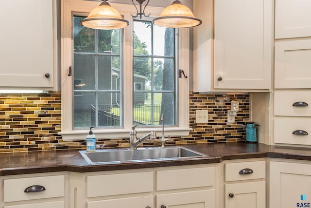 kitchen with backsplash, white cabinets, and hanging light fixtures