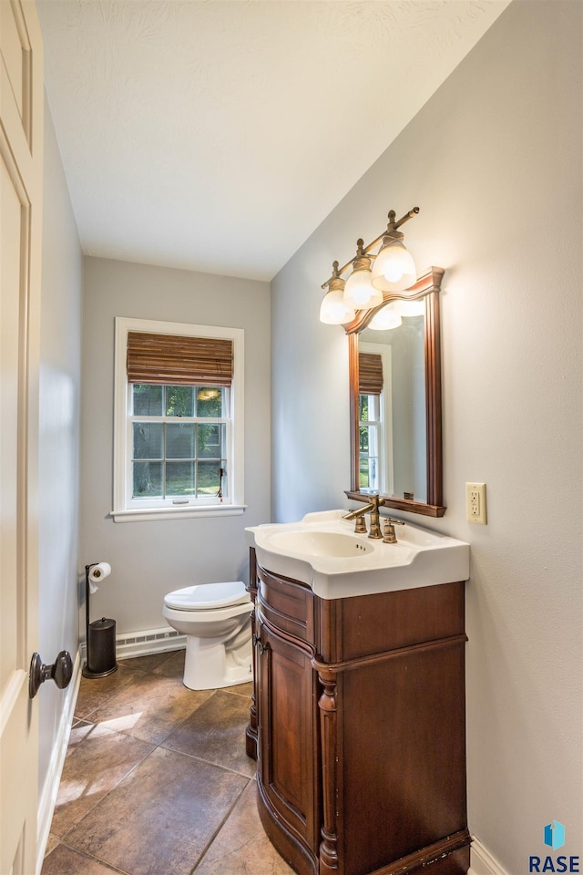 bathroom with vanity, toilet, and a baseboard radiator