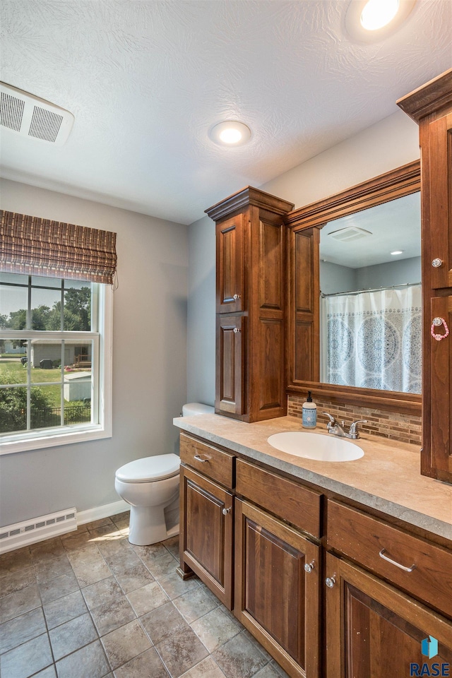 bathroom featuring backsplash, a textured ceiling, vanity, a baseboard radiator, and toilet