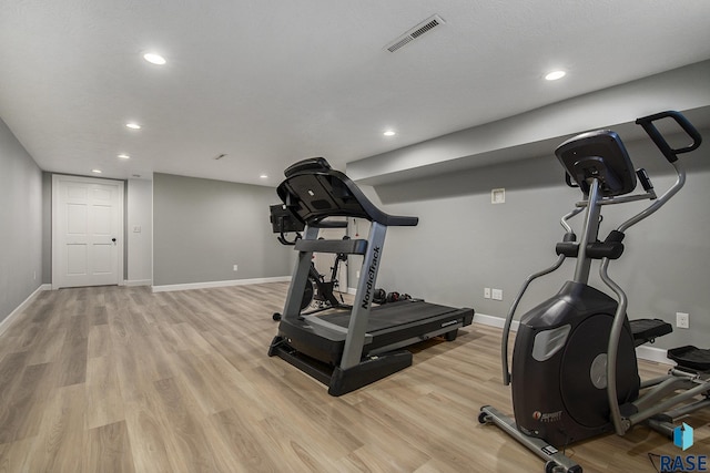 exercise room with light hardwood / wood-style floors