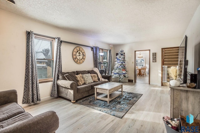 living room with light hardwood / wood-style floors and a textured ceiling