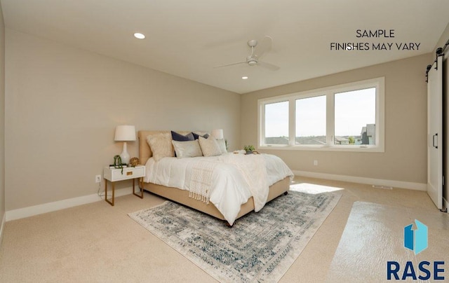 carpeted bedroom with a barn door and ceiling fan