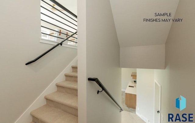 staircase featuring carpet flooring and vaulted ceiling