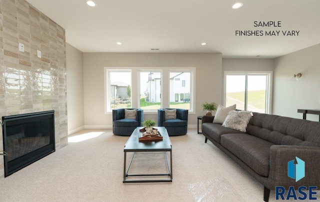 carpeted living room with a tile fireplace