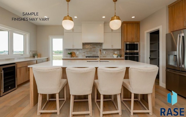 kitchen featuring wine cooler, white cabinetry, pendant lighting, and appliances with stainless steel finishes