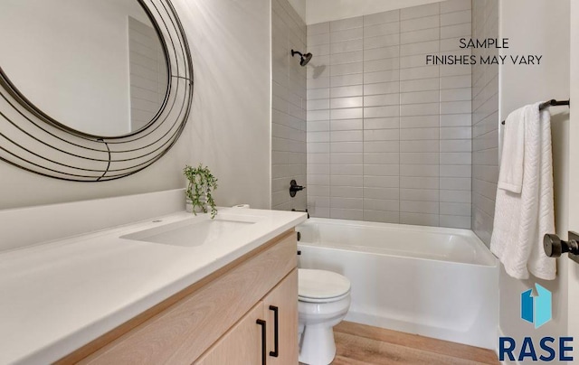 full bathroom featuring tiled shower / bath combo, toilet, wood-type flooring, and vanity