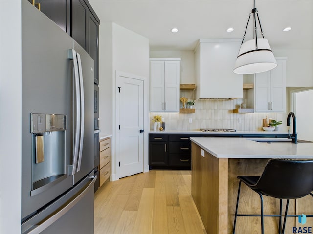 6609 E Hawker Cir, Sioux Falls, SD 57110 - kitchen featuring stainless steel appliances, open shelves, light wood-style floors, light countertops, and a sink