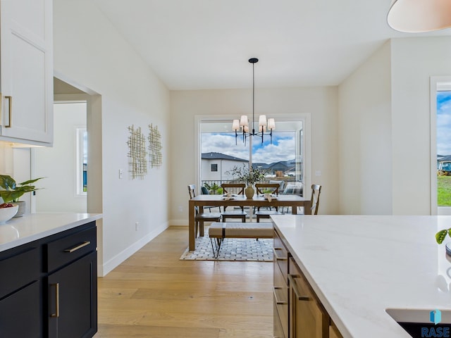 6609 E Hawker Cir, Sioux Falls, SD 57110 - dining area featuring light wood-type flooring, healthy amount of natural light, a chandelier, and baseboards