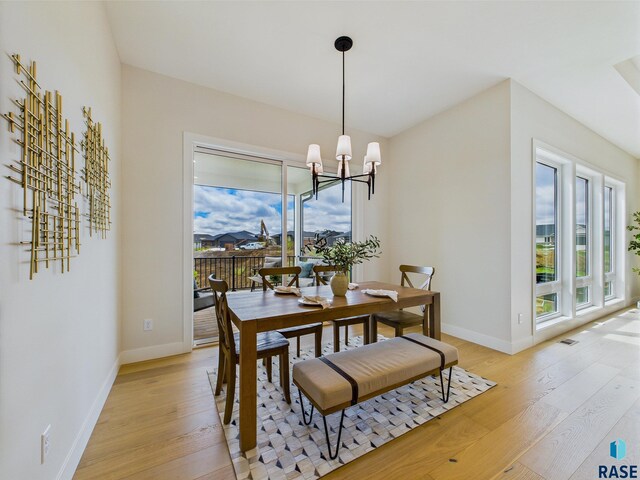 6609 E Hawker Cir, Sioux Falls, SD 57110 - dining area featuring healthy amount of natural light, light wood-style floors, a chandelier, and baseboards