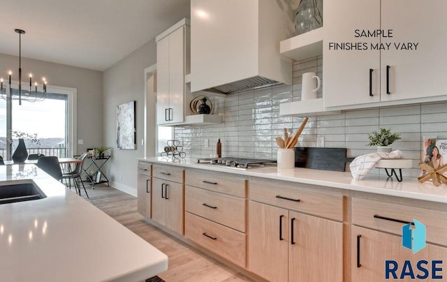 kitchen with light hardwood / wood-style flooring, pendant lighting, decorative backsplash, light brown cabinetry, and custom exhaust hood