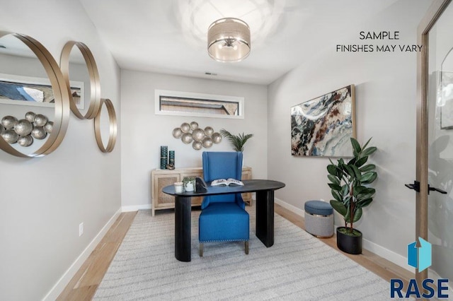 home office featuring plenty of natural light, wood finished floors, visible vents, and baseboards