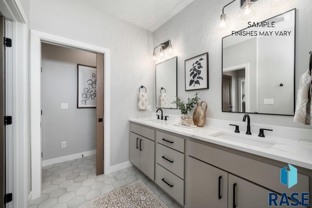 full bath featuring double vanity, baseboards, a sink, and tile patterned floors