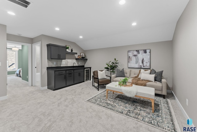 living area with beverage cooler, visible vents, light colored carpet, and recessed lighting