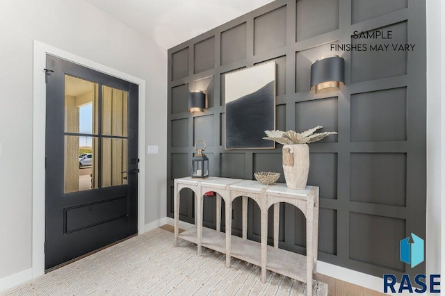 mudroom with built in shelves and light wood-type flooring