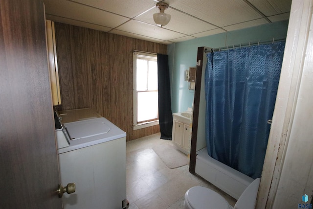 full bathroom featuring a paneled ceiling, shower / bath combo, wood walls, and toilet