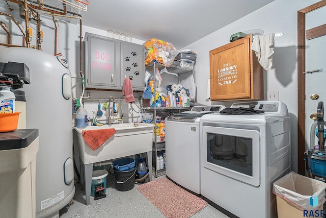 clothes washing area with cabinets, separate washer and dryer, and water heater