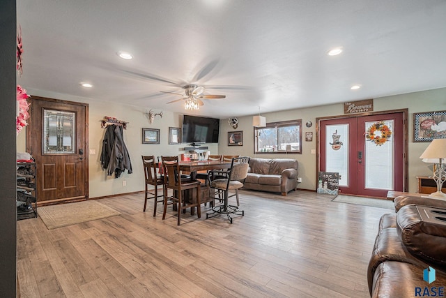 dining space featuring french doors, light wood-type flooring, and ceiling fan