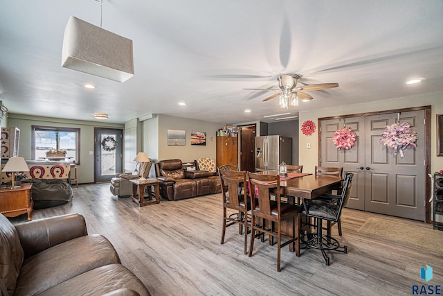 dining space with ceiling fan and light hardwood / wood-style flooring